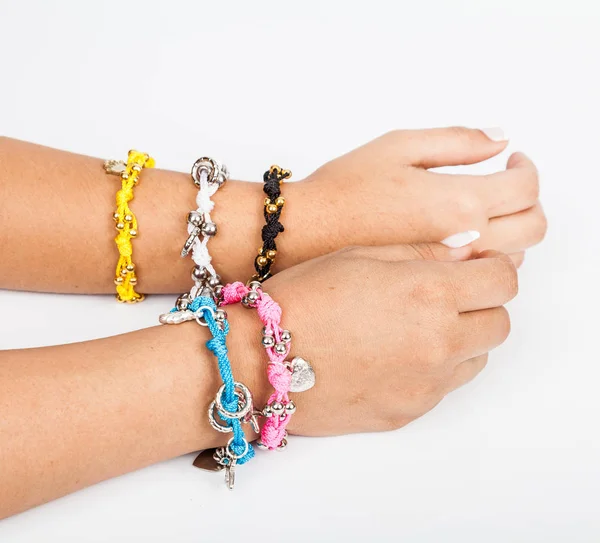 Woman\'s hand wearing jewelry accessory bracelets in neutral background