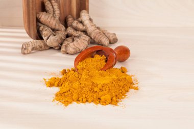 Zerdeçal tozu ve ahşap arka plan (Curcuma longa üzerinde taze zerdeçal)