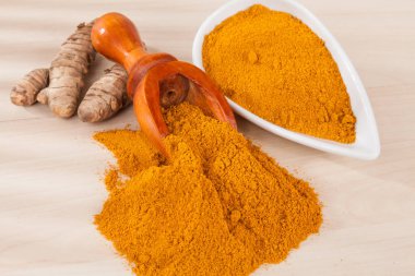 Zerdeçal tozu ve ahşap arka plan (Curcuma longa üzerinde taze zerdeçal)