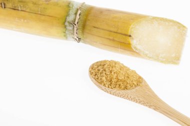 kahverengi şeker, beyaz zemin üzerine tahta kaşıkla