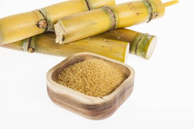 Beyaz arka plan üzerinde ahşap bir kasede kahverengi şeker