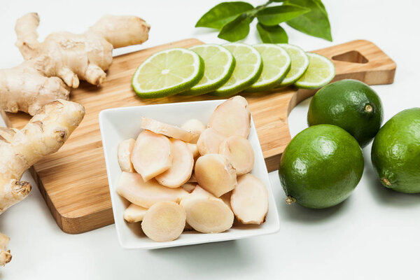 Корень имбиря и лимоны; фото на нейтральном фоне

