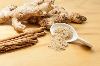 Tarçın ile zencefil kökü; ahşap arka plan üzerinde