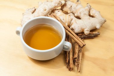 İçecek zencefil kökü ile yapılan ve tarçın; ahşap arka plan üzerinde fotoğraf