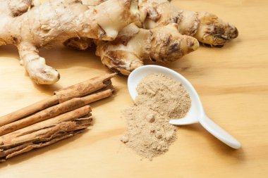 Tarçın ile zencefil kökü; ahşap arka plan üzerinde