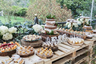 Tatlılar, atıştırmalıklar ve pasta ile dekore edilmiş masa - etkinlik konukları için düğün resepsiyonu.