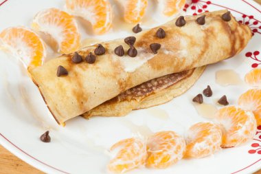 Lezzetli ve sağlıklı kahvaltı, diyet çikolatalı cipsler ve bal ile sarılmış krepler..