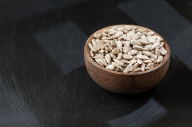 Dehulled Rich ve Besleyici Ayçiçeği tohumlarıyla ahşap kase.