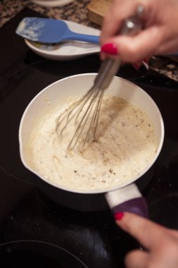 Tavada beşamel sosu çırpıyorum. İtalyan lazanyası için ev yapımı beşamel sosu bulanıklaştırılmış hareket.