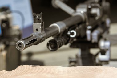 Ön görüşlü, mekanik detaylar ve askeri hassasiyetle monte edilmiş makineli tüfek namlusuna yakın çekim..