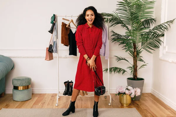 Happy buyer in red dress posing in studio