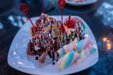 Akşam üzeri siyah taş bir masada çikolatalı dondurma.