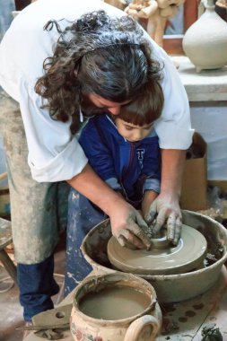 Avrupa, Romanya, Denizcilik, Baia Sprie, Casa Olarului Konuk Evi. Çömlek atölyesi. Daniel Les, baba oğlunun çömlek yapmasına yardım ediyor..