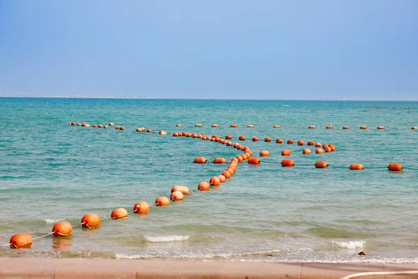 Asia,Western Asia, Arabian Peninsula, Persian Gulf, State of Qatar. Doha. Orange buoys in bay.