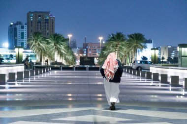 Katar Devleti, Doha. Akşam mermer geçit yürüme geleneksel giyimli adam. 26 Şubat 2017