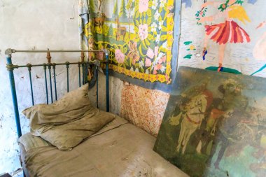 Doğu Avrupa, Ukrayna, Pripyat, Çernobil. Terk edilmiş bir ev, iç mekan. Dekoratif kumaşlar ve resimler ile yatak. 09 Nisan 2018.