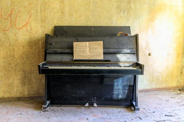 Eastern Europe, Ukraine, Pripyat, Chernobyl. Remains of upright piano and music. April 09, 2018. clipart