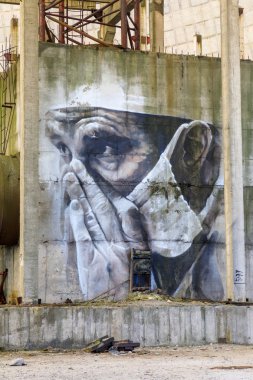 Doğu Avrupa, Ukrayna, Pripyat, Çernobil. 10 Nisan 2018. Bitmemiş soğutma kulesinin içinde, bir duvar resmi yorgun bir doktoru tasvir eder. Avustralyalı sanatçı Guido van Helton tarafından 2016 yılında Igor Kostin'in bir fotoğrafından uyarlanan bir resim. 