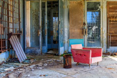 Doğu Avrupa, Ukrayna, Pripyat, Çernobil. Mercan renkli bir modernist sandalye terk edilmiş bir binanın dışında oturuyor.