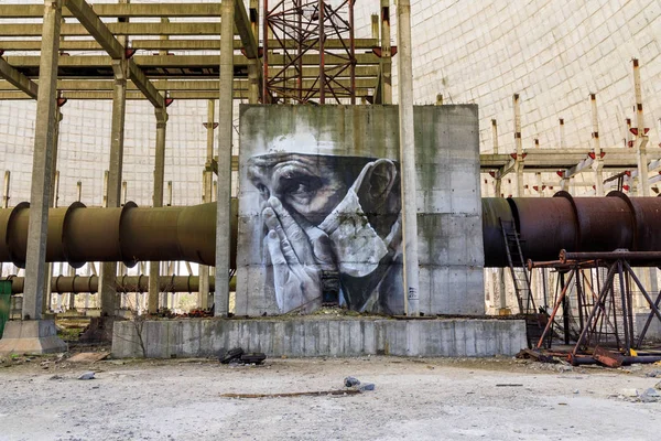 Doğu Avrupa, Ukrayna, Pripyat, Çernobil. 10 Nisan 2018. Bitmemiş soğutma kulesinin içinde, bir duvar resmi yorgun bir doktoru tasvir eder. Avustralyalı sanatçı Guido van Helton tarafından 2016 yılında Igor Kostin'in bir fotoğrafından uyarlanan bir resim. 