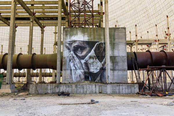 Eastern Europe, Ukraine, Pripyat, Chernobyl. April 10, 2018. Inside the unfinished cooling tower, a mural depicts a tired doctor. Painted by Australian artist Guido van Helton in 2016 based on a photograph by Igor Kostin. 