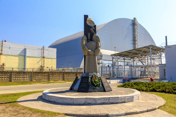 Eastern Europe,Ukraine, Pripyat, Chernobyl. Memorial monument stands in front of Reactor 4, now covered by the new containment sarcophagus completed in 2017. April 10, 2018.
