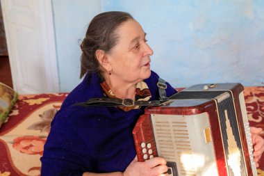 Doğu Avrupa, Ukrayna, Pripyat, Çernobil. Babushkas olarak bilinen Çernobil'de yaşayan kadın. Dairesinde akordeonlu oynuyor. 11 Nisan 2018.