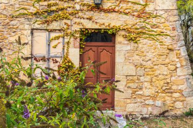 Avrupa, Fransa, Dordogne, Hautefort. Hautefort kasabasındaki taştan bir evde kahverengi bir kapı..