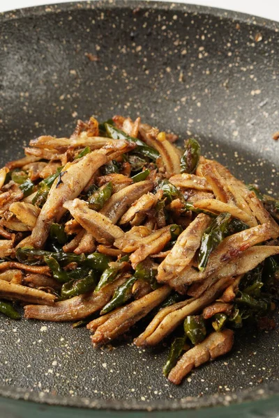 Delicious salted fish stir-fry with green chilies, perfect with warm white rice, each bite a delightful experience.