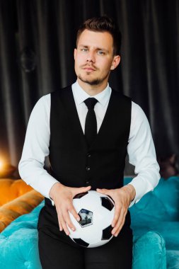 Bir futbol topu tutan bir iş kostüm yelek şık spor adamı. futbolcu.