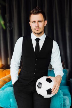 Bir futbol topu tutan bir iş kostüm yelek şık spor adamı. futbolcu.