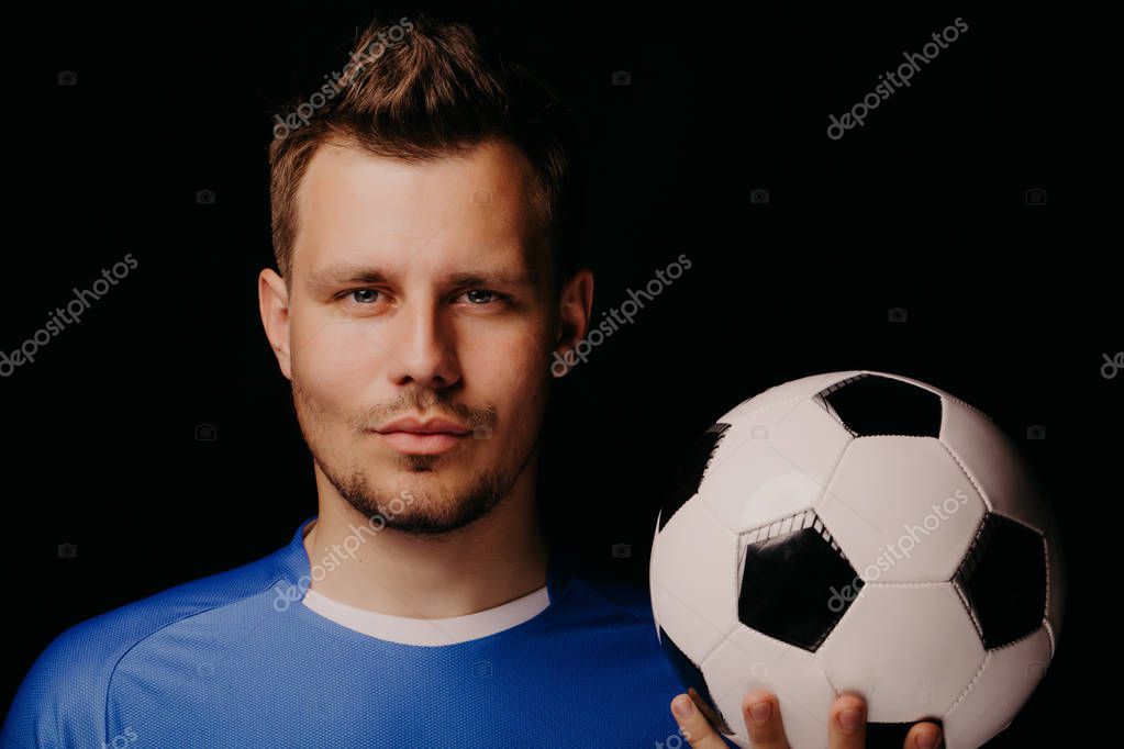 Close Up Portrait Of Young Handsome Football Player Soccer Posing On Black Dark Background And Holds The Ball In His Hand Blue Outfit Bristles Blue Eyes Larastock Close Up Portrait Of Young Handsome Football Player Soccer Posing On Black Dark Background And Holds The Ball In His Hand Blue Outfit Bristles Blue Eyes Larastock