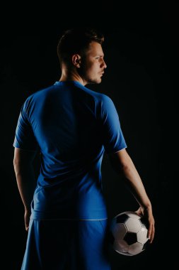 Genç futbolcu topa Studio siyah arka plan ile.