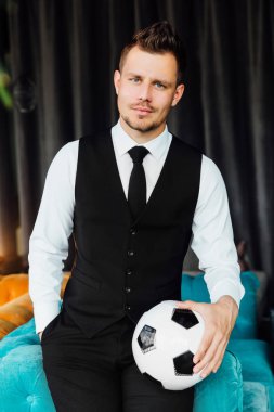 Bir futbol topu tutan bir iş kostüm yelek şık spor adamı. futbolcu.