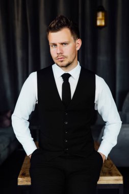 Bir iş sahibi kostüm yelek şık atletik ofiice adam. arka plan bir iç Cafe çatı.