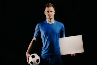 Genç yakışıklı futbol oyuncu futbol topu ve beyaz beyaz boş tutan.