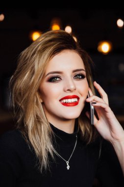 Genç kadın ile telefonu kafede masada söz.