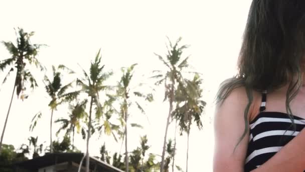 에 긴 머리를 가진 행복 한 어린 소녀는 줄무늬 수영복와 전화에 반바지에. — 비디오