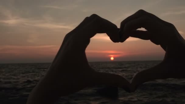 Žena dělat srdce tvar cedulka s rukama na západu slunce dívku drží symbol lásky — Stock video