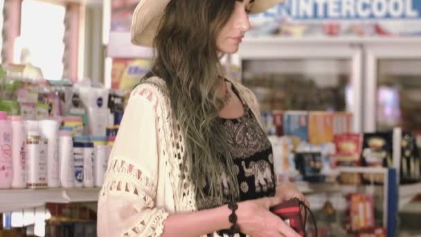 La chica del sombrero paga en la tienda con efectivo . — Vídeo de stock