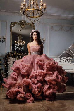 Stüdyo piyano şık bir iç tasarıma poz bulut elbiseli güzel seksi esmer.