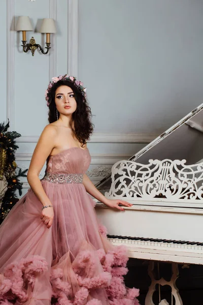Stüdyo piyano şık bir iç tasarıma poz bulut elbiseli güzel seksi esmer.