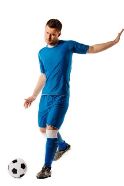 Genç yakışıklı futbolcu beyaz izole arka plan üzerinde poz tekme futbol topu tutuyor.