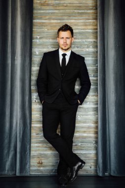 Bir iş sahibi kostüm yelek şık atletik ofiice adam. arka plan bir iç Cafe çatı.