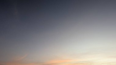 Güzel bir şafak vakti gökyüzü, üzerinde derin bir maviden soluk bir griye yumuşak pembe ve turuncu bir ufka doğru pürüzsüz bir eğimle. İnce, ince bulutlar zar zor görünüyor..