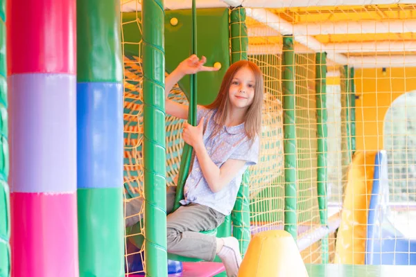 cute girl plays in the play area on background
