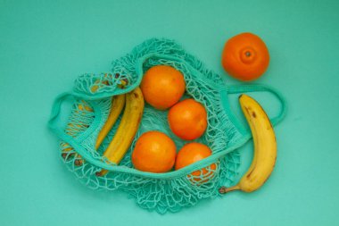 Mandalina ve portakallar yeni bir nane torbasında yatıyor.