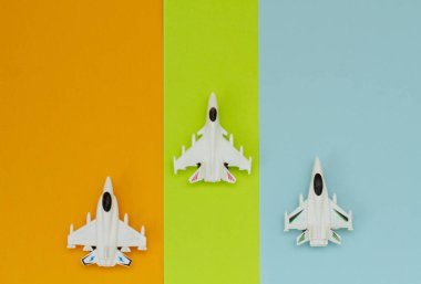 Renkli kağıt üzerinde üç oyuncak uçak. Yukarıdan görüntüle.
