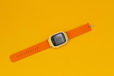 Turuncu arka plandaki akıllı saat. Kırık cam bir aletin üzerinde.