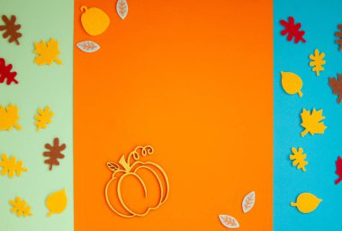 Cadılar Bayramı partisi için kağıt yaprakları turuncu arka planda serili.. 